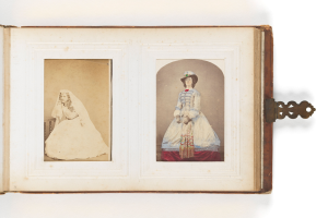 Ein altes Buch mit einer Illustration einer Braut in einem weißen Kleid mit Schleier und Tiara und eines Bräutigams in einem Anzug, der einen Blumenstrauß hält, beide strahlend und glücklich aussehend.