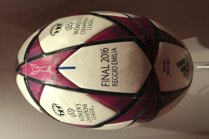 Ein Fußball auf einem weißen Tisch mit der Aufschrift "UEFA Frauen Champions League Finale 2016" in Weiß, Rosa und Schwarz.