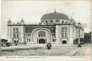 Ein altes Schwarz-Weiß-Foto der Tempelkirche in Czernowitz, Deutschland, umgeben von Menschen, Pfählen, Bäumen und Drähten, mit dem prominenten Kuppelaufbau der Kirche.
