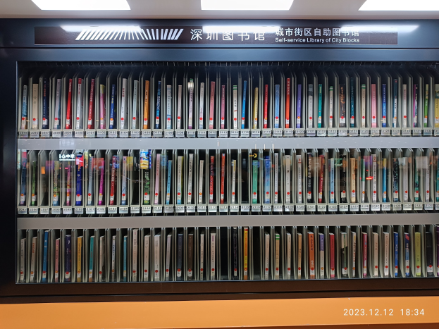 Eine gut beleuchtete Bibliothek mit hohen Bücherregalen voller Bücher, mit einer Texttafel und einem Wasserzeichen unten.