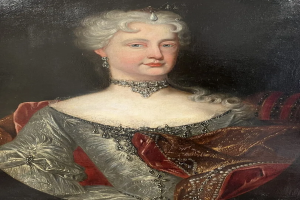 Ein Bild einer Frau in einem roten Kleid, die mutmaßlich Königin Victoria ist, mit dunklem Hintergrund, einem Halsband und einer königlichen Frisur, mit feinen Gesichtszügen und seitlich schauenden Augen.