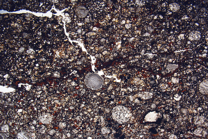 Nahaufnahme einer rissigen, schmutzigen Straße mit einer rauen, unebenen Oberfläche.