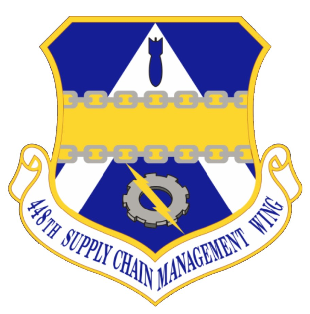 Logo des 48. Versorgungsgeschwader mit einem blauen Schild, einem weißen Stern und einem weißen Banner mit der Aufschrift "Versorgungsgeschwader" in blau, alles von einem weißen Rand und schwarzem Text umgeben.