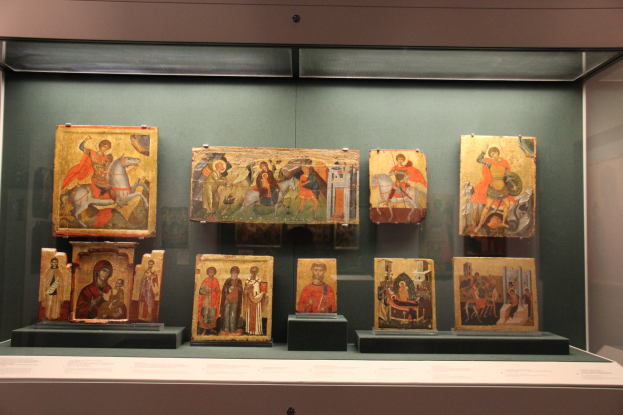 Vitrine mit gerahmten paintings in einem Glasgehäuse in einem Museum.