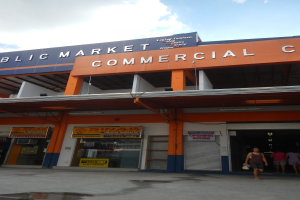 Öffentlicher Markt mit Menschen davor, Text auf dem Gebäude und Himmel darüber