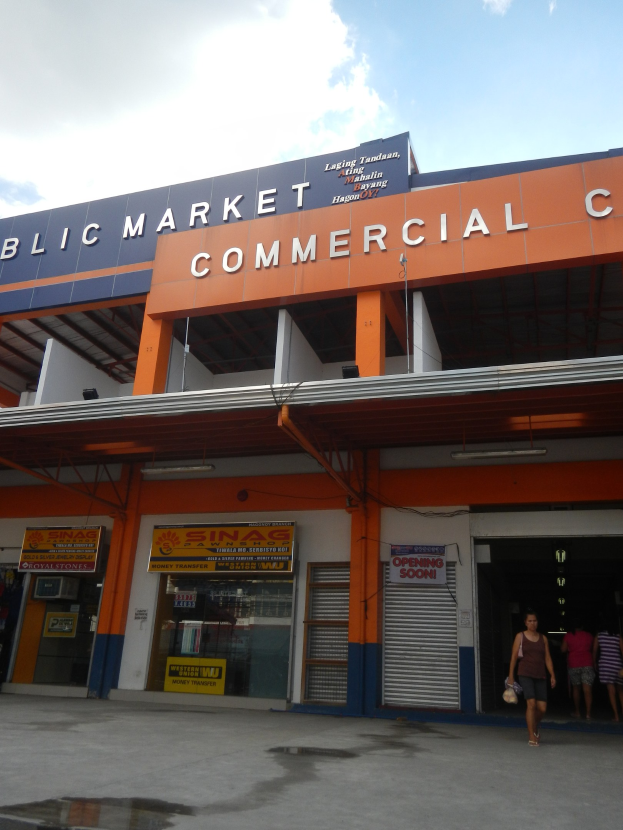Öffentlicher Markt mit Menschen davor, Text auf dem Gebäude und Himmel darüber
