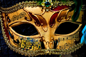 Ein Nahaufnahme eines Faschingsmasken mit Musiknoten, detaillierten Designs und Federn, mit einem unscharfen Hintergrund.