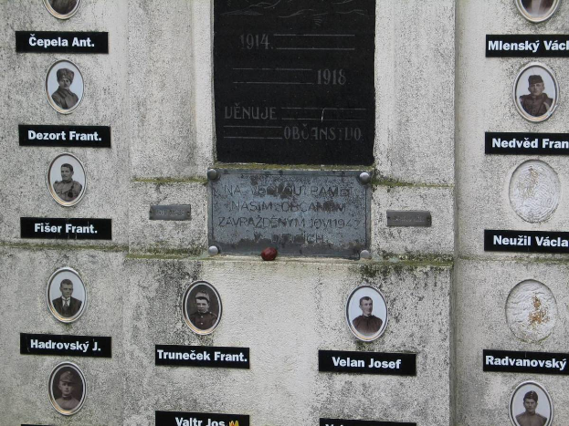 Eine Gedenktafel an einer Wand mit Fotos von Individuen und Text, die diejenigen ehrt, die im Zweiten Weltkrieg ihr Leben verloren haben.