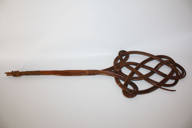 Braune Lederpeitsche mit einem Knoten vor einem weißen Hintergrund.