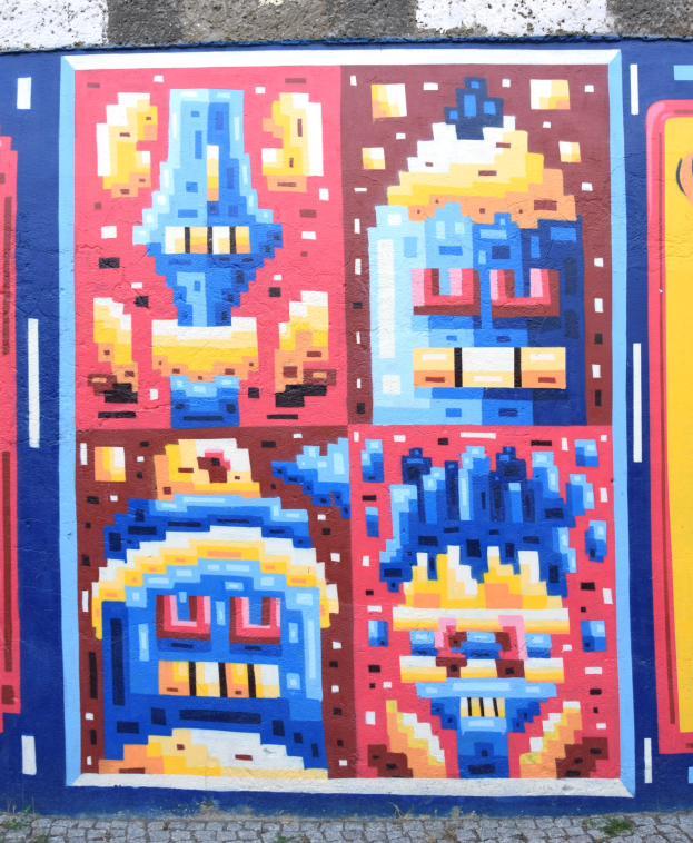 Ein leuchtendes, farbenfrohes Wandgemälde, das die Seite eines Gebäudes in Berlin, Deutschland, bedeckt und aus abstrakten Formen und Designs besteht.