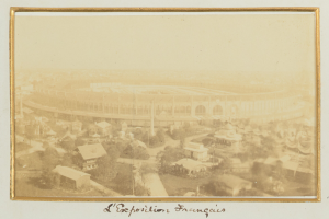 Altes Schwarz-Weiß-Foto eines Stadions in städtischer Umgebung mit umliegenden Gebäuden, Bäumen und Strommasten, mit Text unten.