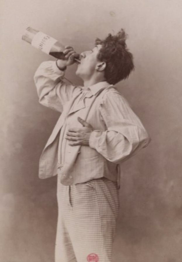 Ein Mann auf einem alten Schwarz-Weiß-Foto, mit ernster Miene, trinkt aus einer Flasche.
